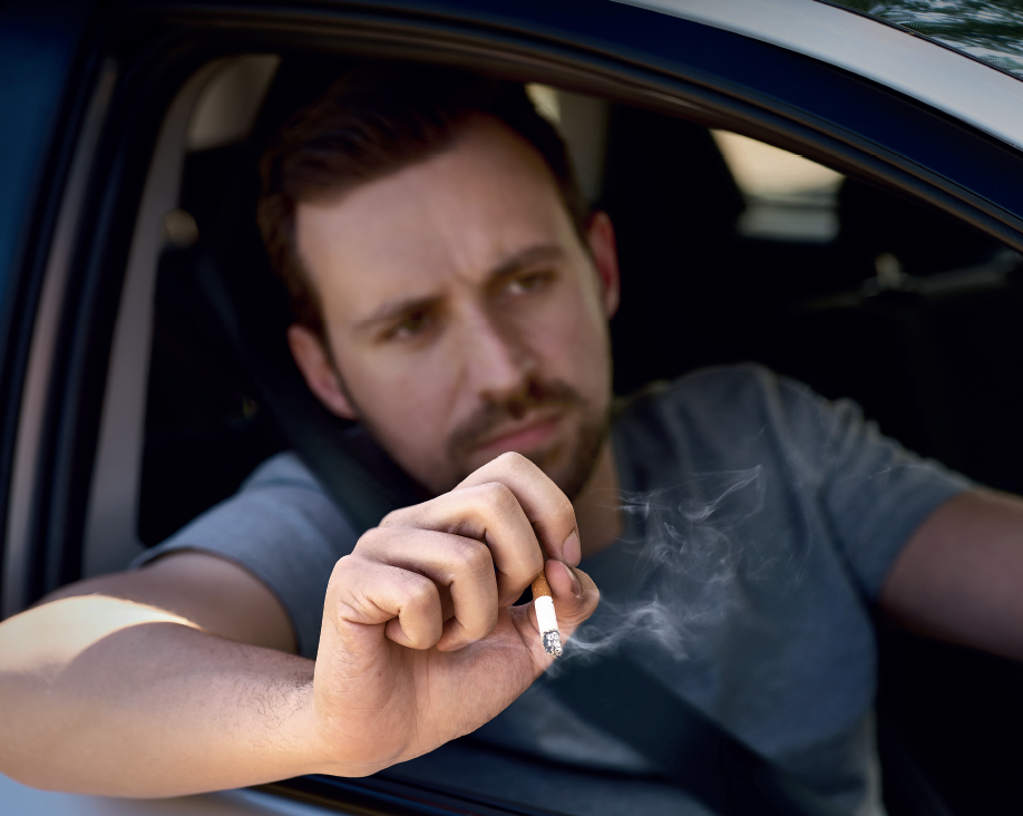 Man dropping cigarette butt from car